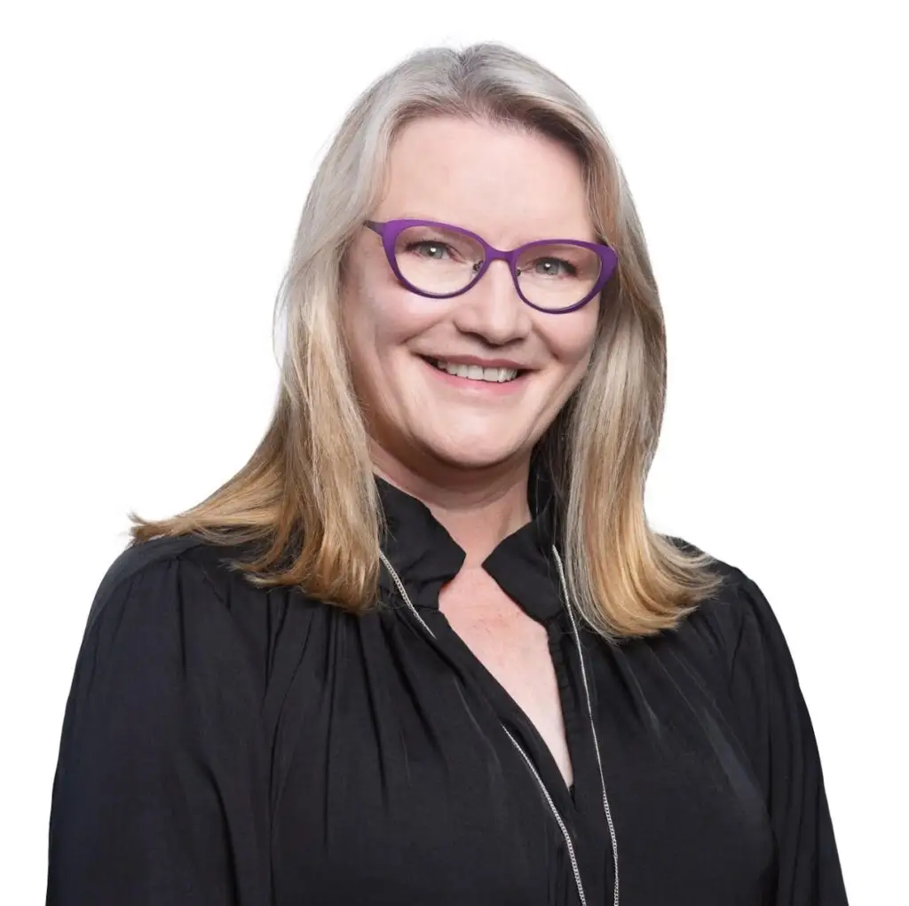 a woman wearing glasses and smiling